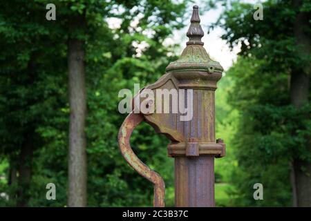 Handwasserpumpe. Alte manuelle Pumpe Brunnen im Park. Foto des alten Stils gut Objekt. Alte antike Metallmechanik. Stockfoto