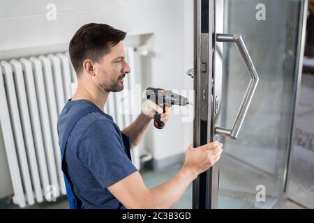 Portrait Junge männliche Tischler reparieren Türschloss Stockfoto