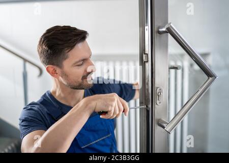 Portrait Junge männliche Tischler reparieren Türschloss Stockfoto