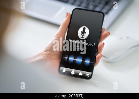 Zugeschnittenes Bild der Frau mit Mobiltelefon mit Wie kann ich Ihnen helfen? Text Stockfoto