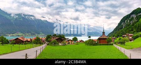 Panoramablick auf Schweizer Dorf Iseltwald mit traditionellen Holz Kirche auf dem südlichen Ufer des Brienzersees, Schweiz Stockfoto