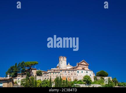 Blick auf die antike Stadt Amelia, in Umbrien. Die Grenzmauer, die Häuser und die Kathedrale mit dem dodekagonalen Turm auf der Spitze des Hügels. Der Stockfoto