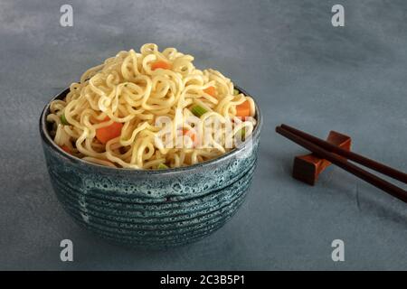 Nudelschüssel mit Karotten und Hengsten, mit Essstäbchen Stockfoto