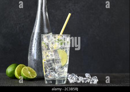 Glas Sekt mit Eiswürfeln und Kalkscheibe Stockfoto