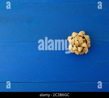 Goldene Schleife auf blauem Holzhintergrund aus Bretter, Platz für eine Beschriftung Stockfoto