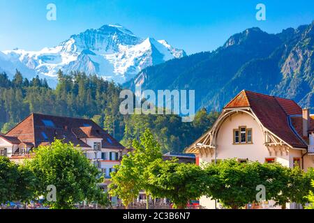 Häuser in der Altstadt von Interlaken, wichtige touristische Zentrum im Berner Oberland, Schweiz. Die Jungfrau ist im Hintergrund sichtbar Stockfoto