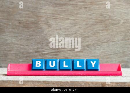 Fliesenbuchstabe auf rotem Gestell in Wort Bully auf Holz Hintergrund Stockfoto
