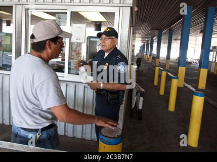 Laredo, Texas, USA, 2012: An einem Zoll- und Grenzschutzkontrollpunkt der USA an der Grenze zwischen den Vereinigten Staaten und Mexiko spricht an mit Lkw-Fahrern, die von Mexiko aus in die Vereinigten Staaten kommen, an der World Trade Bridge. © MKC/Daemmrich Photos Stockfoto