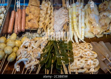 Portionen Fleisch, Würstchen, Kartoffeln, Meeresfrüchte und Gemüse auf Holzstäbchen schneiden, bereit zum Grillen auf der Straße im muslimischen Viertel, Xian Stadt, Stockfoto