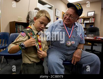 Dime Box Texas, USA, 12 2012. November: Der 13-jährige Pfadfinder zeigt einem Veteranen des Koreanischen Krieges seine Verdienstabzeichen während einer Feier zum Veteranentag in einer Schule in der Kleinstadt. ©MKC / Daemmrich Photos Stockfoto
