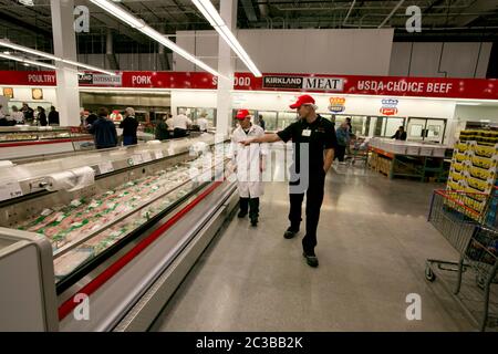 Cedar Park Texas, USA, November 22 2013: Mitarbeiter der Fleischabteilung diskutieren im neu eröffneten Lagerhausclub Costco in einem schnell wachsenden Vorort Austin über Waren. ©Marjorie Kamys Cotera/Daemmrich Photography Stockfoto