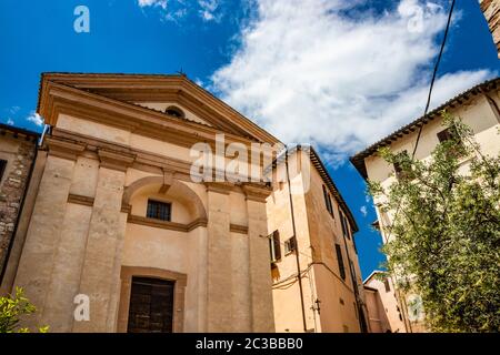 1. Juni 2019 - Spello, Perugia, Umbrien, Italien - EINE Kirche mit einem Tympanon und einer Holztür im historischen Zentrum. Stockfoto