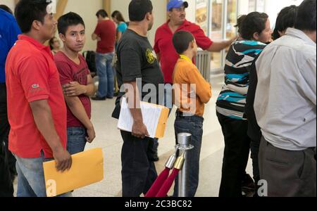 McAllen Texas USA, Juni 24 2014: Freiwillige von Catholic Chararities USA helfen Einwanderern, die kürzlich über die Grenze zwischen Texas und Mexiko illegal in die USA eingereist sind, indem sie Informationen und Beratung an der Bushaltestelle anbieten. ©Marjorie Kamys Cotera/Daemmrich Photography Stockfoto