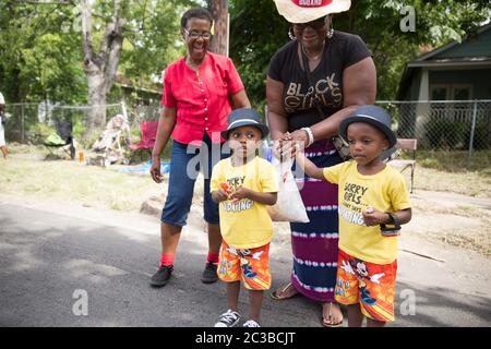 Juneteenth Parade--Austin, Texas, USA, Juni 21 2014: Die jährliche Juneteenth Parade geht im Rahmen einer ganztägigen Feier durch East Austin. Juneteenth, auch bekannt als „Tag der Freiheit“ oder „Emanzipationstag“, feiert das Ende der Sklaverei in den Vereinigten Staaten am Ende des Bürgerkriegs oder des Krieges zwischen den Staaten. Diese kleinen Jungs tragen dieselben Hemden, Shorts und Hüte. ©Marjorie Kamys Cotera/Daemmrich Photography Stockfoto