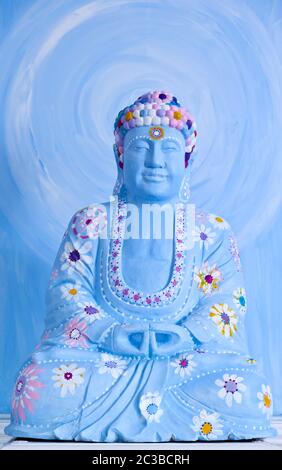 Fröhliche Buddah in Blau mit farbenfroher Dekoration Stockfoto