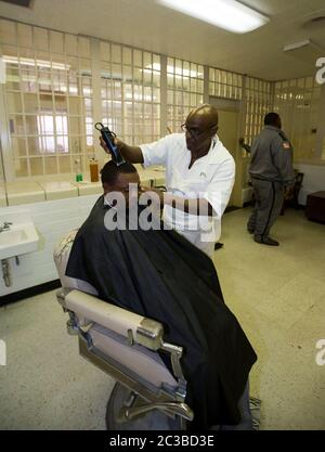 Rosharon Texas, USA, August 25 2014: Unter Aufsicht eines Wärters schneidet ein männlicher Insasse im Friseursalon der Darrington Unit, einem reinen Männergefängnis, das Teil des Gefängnissystems des Texas Department of Criminal Justice ist, die Haare eines anderen Insassen. ©Marjorie Kamys Cotera/Daemmrich Photography Stockfoto