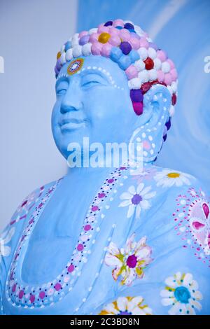 Gesicht der glücklichen Buddah Figur in blau mit farbenfroher Dekoration Stockfoto