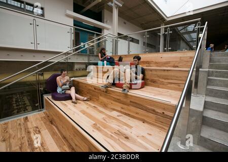 Austin, Texas, USA, 27. August 2014: Die Studenten entspannen sich und lesen auf den Bänken im Treppenhaus des neuen Campus des Austin Community College, der in einem ehemaligen Einkaufszentrum errichtet wurde. ©Marjorie Kamys Cotera/Daemmrich Photography Stockfoto