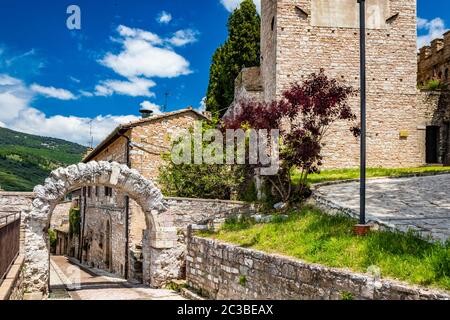 Die gepflasterten Gassen des Dorfes und die Stein- und Ziegelhäuser. Ein römischer Steinbogen. Die gepflasterten Straßen. In Spello, Provinz Perugia, Umbrien, Italien Stockfoto