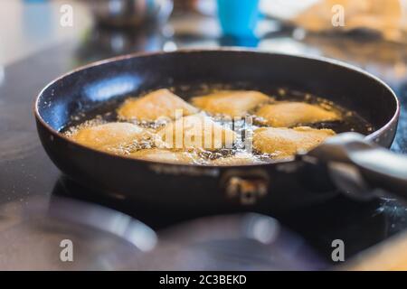 Gebratene portugiesische und brasilianische Frikadellen in einer Pfanne in einer Küche Stockfoto