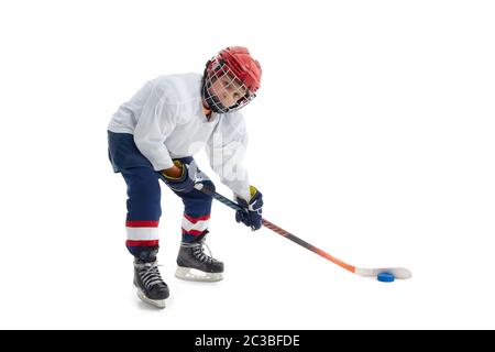 Junior Eishockey-Spieler . Kind (Junge) ist Hockeyspieler in Uniform mit voller Ausrüstung auf weißem Hintergrund isoliert. Konzept des Kindersports, WINT Stockfoto