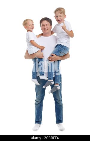 Freundliche Familie. Junger Mann mit zwei Kindern steht isoliert auf weißem Hintergrund. Glückliche Eltern. Vater mit zwei Söhnen. Konzept von Mensch und Familie Stockfoto