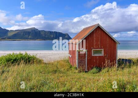 Sonniger Strand von Ramberg (Lofoten Island, Norwegen) mit roter Hütte Stockfoto