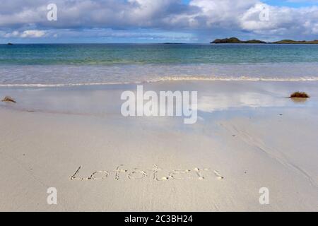 Sonniger Strand von Ramberg (Lofoten Island, Norwegen) mit dem im Sand geschriebenen Wort "Lofoten" Stockfoto