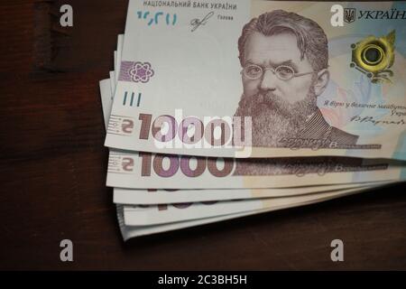 Pack von neuen ukrainischen 1000 Griwna Rechnung. Bündel Papiergeld auf einem hölzernen Hintergrund. Cash Money-Konzept. Nahaufnahme. Vermögenskonzept Stockfoto