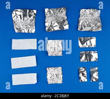 Verschiedene zerknittert weißes Papier und Folie verwendet candy Wrapper auf blauem Hintergrund, Ansicht von oben Stockfoto