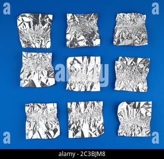 Verschiedene zerknitterte Folie verwendet candy Wrapper auf blauem Hintergrund, Ansicht von oben Stockfoto