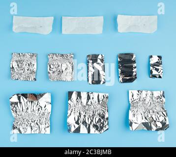 Verschiedene zerknittert weißes Papier und Folie verwendet candy Wrapper auf blauem Hintergrund, Ansicht von oben Stockfoto