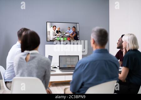 Gruppe von Geschäftsleuten mit Video-Konferenz im Sitzungssaal Stockfoto