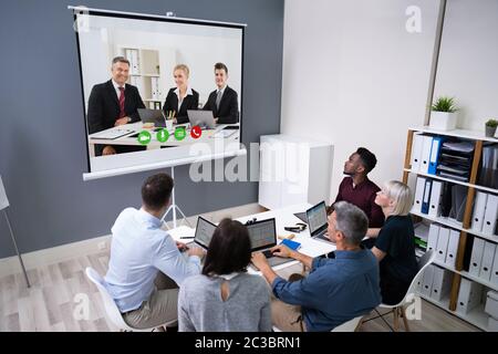 Gruppe von Geschäftsleuten mit Video-Konferenz im Sitzungssaal Stockfoto