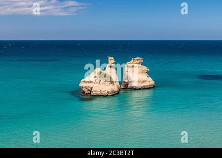 Die Bucht von Torre dell'Orso, mit seinen hohen Klippen, in Salento, Apulien, Italien. Türkisfarbenes Meer und blauer Himmel, sonniger Tag im Sommer. Die Stapel nannten die TW Stockfoto