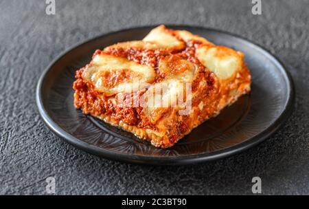 Teller Lasagne auf schwarzem Hintergrund Stockfoto
