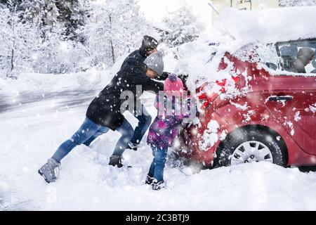 Familie Drücken ein Auto stecken im Schnee Nach starker Schneefall Stockfoto