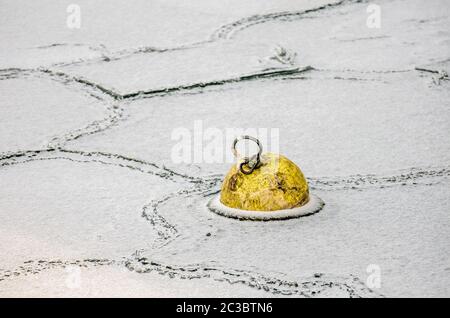 Gefrorene gelbe Boje und abstrakte Eis Textur Hafen in Konstanz, Bodensee, Deutschland Stockfoto
