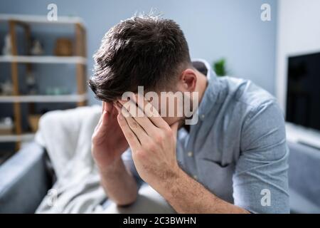 Sorgte Mitte der erwachsene Mann leidet unter Kopfschmerzen zu Hause Stockfoto