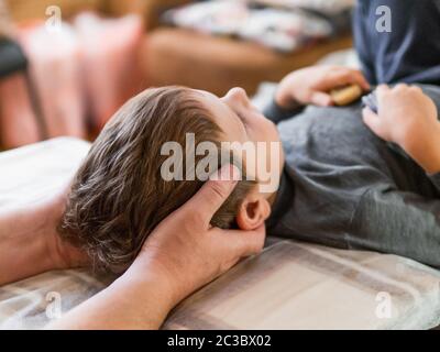 Echten osteopath nicht physiologischen Schädel Therapie für ein Kind. Osteopathie Behandlung. Stockfoto