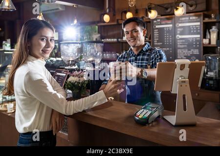 Portrait von asiatische Frau Kunden Kaffee Tasse von Barista im Cafe. Stockfoto