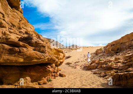 Mann in weißer arabischer Kleidung geht in einem farbigen Canyon in Ägypten Dahab Süd Sinai Stockfoto