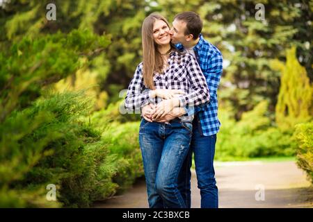 Charmantes gutes Paar Mann und Frau, die durch den Park spazieren, umarmen und Zeit miteinander verbringen Stockfoto