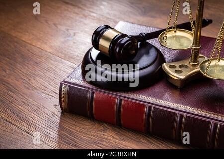 Holz- Hammer mit goldenen Skala in der Nähe von Buch am Tisch Stockfoto