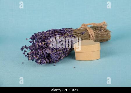Close up Bukett von getrockneten Lavendelblüten und kleinen herzförmigen Geschenkbox auf Blau Tischdecke, hohe Betrachtungswinkel Stockfoto