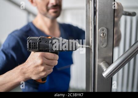 Portrait Junge männliche Tischler reparieren Türschloss Stockfoto