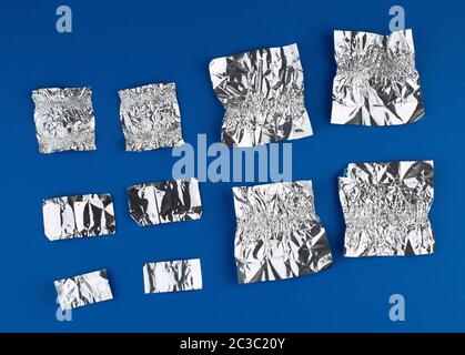 Verschiedene zerknitterte Folie verwendet candy Wrapper auf blauem Hintergrund, Ansicht von oben Stockfoto