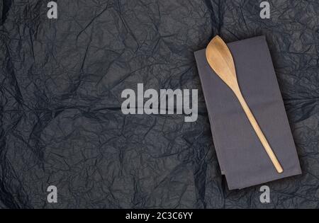 Holzlöffel und Küchentuch auf Seidenpapier. Stockfoto