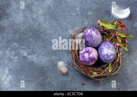 Osterhintergrund mit bemalten Eiern im Nest. Stockfoto