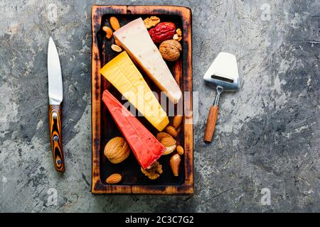 Kochplatten aus Holz mit verschiedenen Käsesorten auf dem Tisch Stockfoto